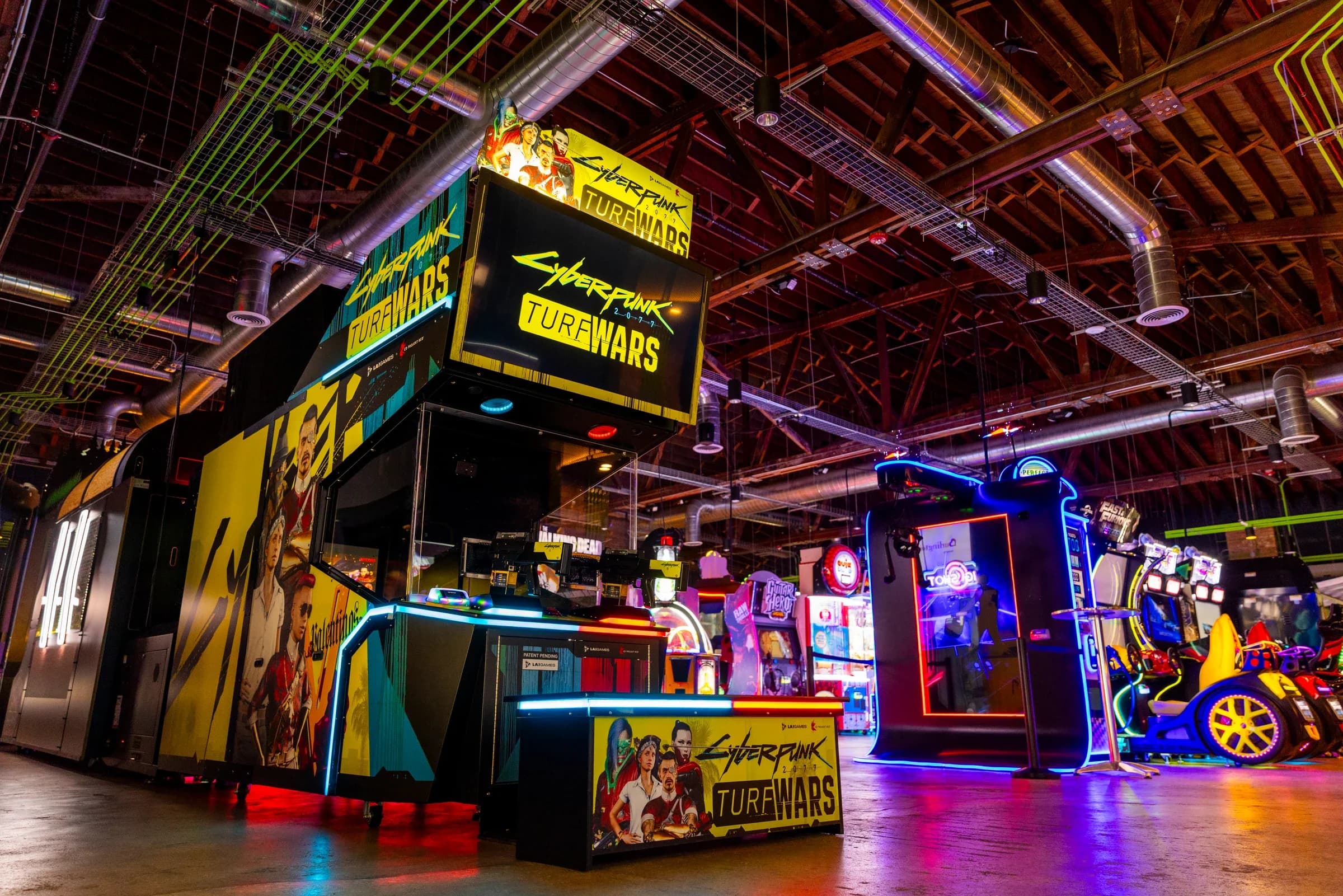 The Cyberpunk Edgerunners Turf Wars and motorcycle sim cabinets at Ignite Arcade.