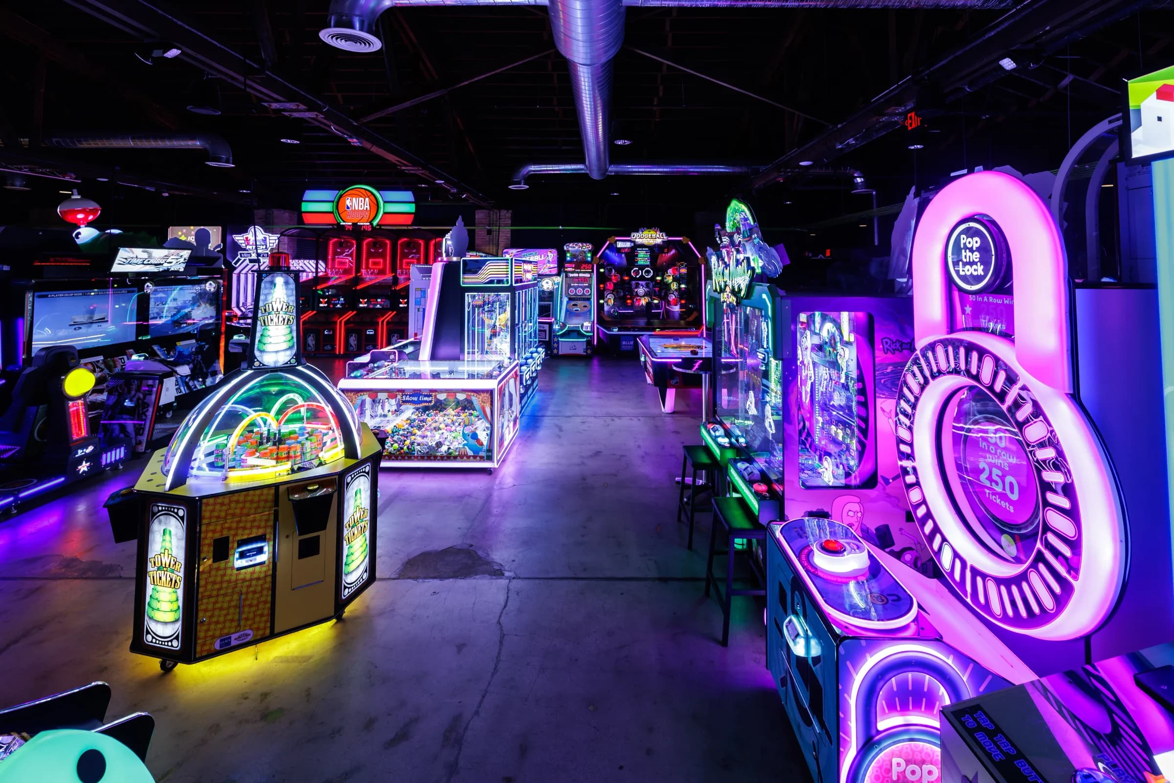 Neon-lit arcade floor with prize redemption games.